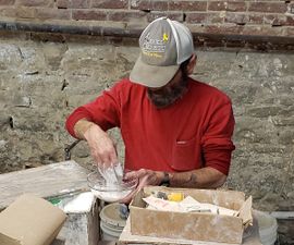 Mixing plaster of Paris. This treatment was developed by Henry Tibbe, the founder of Missouri Meerschaum. Henry found the plaster of Paris process gave the cobs a character similar to Turkish Meerschaum, hence the inspiration for naming his company.